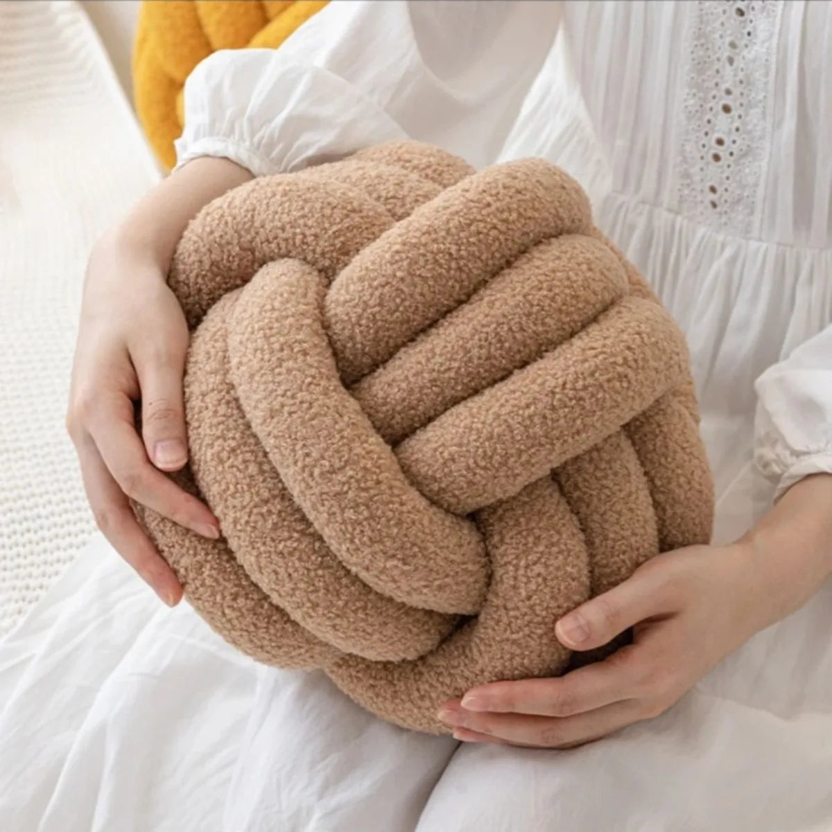Decorative plush pillow with an aesthetically pleasing globe-shaped knot, ideal for sleeping